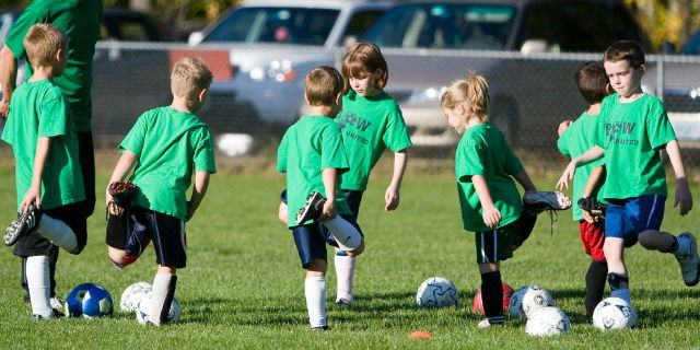 pequeños jugadores de fútbol estirando antes de entrenar